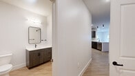 Located at 227 Pane Rd in Newington, CT, this thoughtfully designed 2-bedroom, 2-bathroom single-floor residence offers a clean, contemporary aesthetic throughout. Light wood-tone flooring flows seamlessly across the entire unit, creating a warm and cohesive look. The open-concept living area is bright and airy, with recessed lighting and multiple windows that invite natural light while offering views of the surrounding greenery.

The kitchen is a standout feature, showcasing dark wood-grain cabinetry paired with white quartz countertops, classic subway tile backsplash, and a full suite of stainless steel appliances including a range, microwave, dishwasher, and refrigerator. A peninsula with a sink adds both functionality and a natural division between the kitchen and living space. In-unit washer and dryer hookups add everyday convenience.

Both bedrooms are comfortably sized, each equipped with individual wall-mounted mini-split units for efficient climate control and windows that bring in natural light. The spacious primary bedroom offers ample room for furnishings. The two bathrooms are finished with dark-hardware accents, wood-toned vanities, and white quartz countertops — one featuring a walk-in shower, the other a full soaking tub and shower combination.