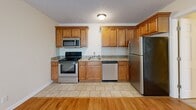 Located at 6301 W Kilgore Ave in Yorktown, Indiana, this well-appointed one-bedroom, one-bathroom unit offers a practical and comfortable single-floor layout. Warm hardwood flooring flows throughout the main living areas and bedroom, creating a cohesive and inviting atmosphere complemented by neutral-toned walls and textured ceilings.

The open living area transitions directly into a fully equipped kitchen, which features warm honey-toned wood cabinetry extending to the ceiling for ample storage, granite countertops, tile flooring, and a full suite of stainless steel appliances including a range, microwave, dishwasher, and refrigerator.

The spacious primary bedroom offers generous room to furnish comfortably, includes a wall-mounted climate control unit, a bright window overlooking the outdoors, and two closets for convenient storage.

The full bathroom is thoughtfully designed with a granite-topped wood vanity, tile flooring, and a shower/tub combo. A standout feature is the inclusion of an in-unit stacked washer and dryer, adding significant everyday convenience. Overall, the unit presents a clean, functional living environment with quality finishes throughout.