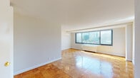 This single-floor residence offers a thoughtfully designed layout that balances open living spaces with practical functionality. Throughout the unit, polished parquet wood flooring in a warm honey tone creates a cohesive and inviting aesthetic, reflecting natural light and adding character to every room.

The spacious living and dining area is a standout feature, bathed in natural light from large floor-to-ceiling windows that frame views of the surrounding cityscape and greenery. A gold chandelier accents the dining area, adding a touch of elegance to the open space. A second room also benefits from generous window placement, drawing in abundant sunlight and urban views.

The bedroom is generously sized and features multiple closets, including a walk-in style closet with built-in shelving, offering excellent storage capacity. The room's clean lines and neutral palette provide a calm, versatile environment.

The bathroom retains a classic mid-century character, finished with light blue ceramic wall tiles and a matching soaking tub, lending the space a distinctive retro charm. The kitchen is efficiently laid out with white cabinetry, dark countertops, a gas range, and classic black-and-white patterned tile flooring, offering a clean and practical cooking environment. Together, these spaces form a well-rounded residence with timeless design details throughout.