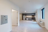 Located at 636 W 6th St in Vancouver, Washington, this efficiently designed single-floor unit offers a clean, modern aesthetic throughout. The open-concept kitchen and living area serves as the heart of the space, featuring light wood-style flooring that extends seamlessly through every room, crisp white walls, and abundant natural light streaming in through large windows and a glass-paned exterior door that opens to an outdoor view.

The kitchen is well-appointed with sleek gray flat-front cabinetry extending to the ceiling, stainless steel appliances including an electric range, dishwasher, and refrigerator, a light stone-finish countertop, and a tasteful tile backsplash. Recessed and under-cabinet lighting add a polished, functional touch.

The living area provides an open, flexible layout with a bright, neutral palette that enhances the sense of space. A dedicated closet with a full rod and shelving offers practical storage, complemented by a louvered utility door nearby.

The bathroom maintains the same contemporary style, showcasing gray cabinetry with brushed nickel hardware, a stone-finish vanity countertop with an undermount sink, a large mirror, and light wood-look tile flooring. Clean white walls and modern fixtures complete the refined, move-in-ready feel of this thoughtfully designed space.