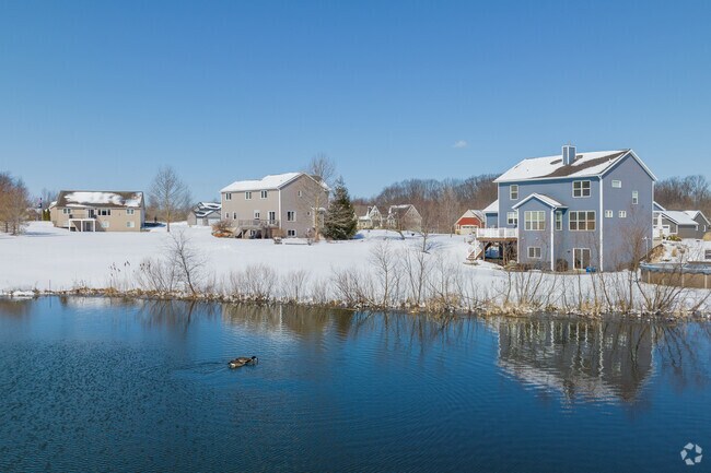 A scenic lake surrounded by houses in Caledonia.