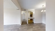 This single-floor, 2-bedroom, 1-bathroom residence offers a well-organized layout designed for comfortable everyday living. The living room serves as the central gathering space, featuring wood-style plank flooring, a textured ceiling, and a sliding glass door that opens to a balcony, allowing natural light and outdoor views to fill the room. A stylish chandelier adds a finishing touch near the dining area, which connects seamlessly to the kitchen via an open pass-through arrangement.

The kitchen is outfitted with gray-toned cabinetry, a subway tile backsplash, marble-look countertops, and stainless steel appliances, including a refrigerator, dishwasher, and microwave. A hallway connects the main living areas to the private quarters of the unit. Both bedrooms feature plush carpeting, neutral walls, and windows that bring in natural light. The primary bedroom offers a generous footprint with a closet featuring built-in shelving and hanging rods. The full bathroom includes a tub/shower combination and marble-look countertop vanity with warm-toned cabinetry. A dedicated closet and hallway complete the functional layout of this well-maintained residence.