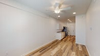 This single-floor, one-bedroom, one-bathroom unit in Metairie, Louisiana offers a clean, modern design with a cohesive neutral palette throughout. Wood-look plank flooring runs continuously across all areas of the unit, contributing to a unified and streamlined aesthetic.

The open living and kitchen area forms the heart of the unit. The kitchen is outfitted with light-toned cabinetry, granite countertops, a stainless steel sink, and a full suite of stainless steel appliances including a refrigerator, range, over-the-range microwave, and dishwasher. Recessed lighting and a ceiling fan illuminate the combined living space, which receives natural light through a window at the far end of the room.

A hallway connects the main living area to the private spaces of the unit. The bedroom is a well-proportioned room with a ceiling fan, a window with blinds, and clean white walls. Adjacent to the bedroom is a closet area with wire shelving, offering functional storage.

The bathroom features a soaking tub and shower combination, a vanity with granite countertop and under-sink cabinetry, a wall-mounted mirror, and wood-look flooring consistent with the rest of the unit. The overall ambiance is bright, fresh, and move-in ready.