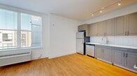 Located at 1001 W Elizabeth Ave in Linden, NJ, this one-bedroom, one-bathroom unit offers a thoughtfully designed layout that maximizes every inch of its compact footprint. The open-concept living, dining, and kitchen area is bright and welcoming, featuring warm hardwood-style flooring that runs throughout the entire unit and large windows that invite generous natural light. A wall-mounted HVAC unit ensures year-round comfort.

The kitchen is well-appointed with grey shaker-style cabinetry extending to the upper and lower walls, a classic white subway tile backsplash, light countertops, and a full suite of stainless steel appliances including a refrigerator, dishwasher, range, and microwave — all illuminated by sleek track lighting overhead.

The bedroom is a comfortable, well-proportioned retreat with soft neutral-toned walls, its own window with natural light, and a wall-mounted HVAC unit. Three closets throughout the unit provide excellent storage capacity.

The bathroom features a frameless glass walk-in shower with tile surround, a grey vanity with a stone-style countertop, and matching hardwood-style flooring. A dedicated laundry area adds everyday convenience. Clean white walls and crisp baseboards throughout give the unit a fresh, modern aesthetic.