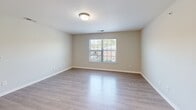 Located at 1911 Spring Garden St in Greensboro, NC, this single-floor residence offers three bedrooms and two bathrooms within a well-designed, functional layout. The open-concept living and kitchen area serves as the heart of the home, featuring light wood-style luxury vinyl plank flooring and a warm, neutral color palette. The kitchen is equipped with dark espresso-toned cabinetry, light granite-style countertops, a peninsula breakfast bar, and black appliances including a range, microwave, refrigerator, and dishwasher, all illuminated by recessed lighting. The living room provides a clean, open canvas with ample wall space and easy access to the rest of the unit. The primary bedroom is a generously sized retreat with soft carpeting, a ceiling fan, a large window for natural light, and a double-door closet. Additional bedrooms also feature carpet flooring and closet storage. One bathroom includes a dark vanity with a white countertop, wood-style flooring, and a tub-shower combo, while the second bathroom offers a straightforward tub-shower setup. A walk-in closet with built-in rod shelving provides additional storage. The consistent neutral tones and clean finishes throughout give this residence a move-in ready, cohesive aesthetic.