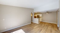This well-appointed 3-bedroom, 2-bathroom single-floor residence offers a thoughtfully designed layout that maximizes comfort and functionality. The living area is open and airy, featuring light wood flooring and neutral warm-toned walls that create a clean, inviting atmosphere. A sliding glass door floods the space with natural light and provides access to an outdoor area with views of surrounding greenery.

The kitchen is designed in a galley style, outfitted with white shaker cabinetry, quartz countertops, and a full suite of stainless steel appliances including a gas range, microwave, and refrigerator. A pass-through peninsula connects the kitchen to the living area, enhancing the open flow of the space.

Both bathrooms are finished with white vanity cabinetry, quartz countertops, brushed nickel fixtures, and light wood flooring. The full bathroom includes a tub-shower combination, while each bathroom benefits from ample mirror space and natural light.

The three bedrooms are finished with consistent neutral tones and light wood flooring. The spacious primary bedroom offers a generous footprint, while a dedicated closet provides additional built-in storage with rod shelving. Hallways connect the rooms efficiently throughout the single-story floorplan, completing a cohesive and practical living space.