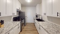 Located at 1102 W Poinsett St in Greer, SC, this single-story home offers a well-designed layout with a clean, updated aesthetic throughout. The living area provides a comfortable, light-filled space with wood-look flooring, neutral walls, and natural light streaming through blinds-fitted windows — creating a welcoming atmosphere for everyday living and entertaining.

The galley-style kitchen stands out with its crisp white shaker cabinetry, granite-look countertops, black hardware accents, a deep black undermount sink, and stainless steel appliances including a range and refrigerator. A dedicated dining area adjacent to the main living space accommodates a dining table, making it functional for meals and gatherings.

The home includes multiple bedrooms, each featuring wood-look flooring, neutral walls, and windows with blinds for natural light and privacy. Several bedrooms offer closet storage, including a reach-in closet with shelving and rod. The bathroom is outfitted with a full tub-shower combination featuring crisp white surrounds and matte black fixtures, maintaining a consistent design theme.

Throughout the home, textured ceilings, clean baseboards, and consistent flooring tie the spaces together cohesively, offering a move-in-ready residence in a convenient Greer location.