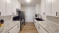 Located at 1102 W Poinsett St in Greer, SC, this single-story home offers a well-designed layout with a clean, updated aesthetic throughout. The living area provides a comfortable, light-filled space with wood-look flooring, neutral walls, and natural light streaming through blinds-fitted windows — creating a welcoming atmosphere for everyday living and entertaining.

The galley-style kitchen stands out with its crisp white shaker cabinetry, granite-look countertops, black hardware accents, a deep black undermount sink, and stainless steel appliances including a range and refrigerator. A dedicated dining area adjacent to the main living space accommodates a dining table, making it functional for meals and gatherings.

The home includes multiple bedrooms, each featuring wood-look flooring, neutral walls, and windows with blinds for natural light and privacy. Several bedrooms offer closet storage, including a reach-in closet with shelving and rod. The bathroom is outfitted with a full tub-shower combination featuring crisp white surrounds and matte black fixtures, maintaining a consistent design theme.

Throughout the home, textured ceilings, clean baseboards, and consistent flooring tie the spaces together cohesively, offering a move-in-ready residence in a convenient Greer location.