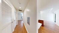 This well-appointed 2-bedroom, 1-bathroom residence offers a thoughtfully designed layout with a clean, contemporary aesthetic throughout. Warm hardwood flooring flows seamlessly across every room, complementing the crisp white walls and modern finishes that define the space.

The kitchen is a standout feature, boasting a refined combination of white upper cabinetry and rich wood-toned lower cabinets, topped with light stone countertops. Stainless steel appliances, including a gas range and refrigerator, add a professional touch, while a marble-style backsplash completes the polished look.

Both bedrooms are generously proportioned and filled with natural light. The primary bedroom features a double closet and floor-to-ceiling glazed panels that open to an expansive outdoor terrace, offering open urban views. The second bedroom also benefits from large black-framed windows that frame city views and allow ample daylight.

The bathroom features a tiled shower with dark, textured wall tiles and chrome fixtures, delivering a clean, spa-inspired feel.

A well-lit central hallway connects all rooms efficiently, with recessed lighting overhead. The highlight of the unit is the large private terrace, accessible directly from the living area and primary bedroom, providing an exceptional outdoor extension of the living space with open city views.