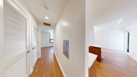 This well-appointed 2-bedroom, 1-bathroom residence offers a thoughtfully designed layout with a clean, contemporary aesthetic throughout. Warm hardwood flooring flows seamlessly across every room, complementing the crisp white walls and modern finishes that define the space.

The kitchen is a standout feature, boasting a refined combination of white upper cabinetry and rich wood-toned lower cabinets, topped with light stone countertops. Stainless steel appliances, including a gas range and refrigerator, add a professional touch, while a marble-style backsplash completes the polished look.

Both bedrooms are generously proportioned and filled with natural light. The primary bedroom features a double closet and floor-to-ceiling glazed panels that open to an expansive outdoor terrace, offering open urban views. The second bedroom also benefits from large black-framed windows that frame city views and allow ample daylight.

The bathroom features a tiled shower with dark, textured wall tiles and chrome fixtures, delivering a clean, spa-inspired feel.

A well-lit central hallway connects all rooms efficiently, with recessed lighting overhead. The highlight of the unit is the large private terrace, accessible directly from the living area and primary bedroom, providing an exceptional outdoor extension of the living space with open city views.
