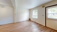 Located at 80 Sandune Drive in Pittsburgh, PA, this two-bedroom, two-bathroom home is thoughtfully arranged across three floors. The entry level hosts a garage with concrete flooring and a utility room, providing practical storage and functional space. The main living level features a bright living room with light hardwood flooring and a window that brings in natural light. The kitchen is well-appointed with warm wood cabinetry, stone-finish countertops, a stainless steel sink, a dishwasher, and a range — all complemented by light hardwood floors and a window overlooking the exterior. Two hallways connect the home's spaces efficiently across levels. The upper floor contains both bedrooms, each carpeted for comfort. The primary bedroom is generously sized and includes a closet, while the second bedroom also offers a window with natural light. Two full bathrooms serve the home — one featuring tile flooring, a wood vanity, and a tub/shower combo, and a second compact bathroom with hardwood flooring. A central staircase connects all three levels. The home's layout offers a practical and comfortable living experience in a residential Pittsburgh neighborhood.