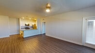 This single-floor residence offers a thoughtfully designed open-concept layout that seamlessly connects the living area to the kitchen. Rich wood-style flooring runs throughout the space, lending warmth and visual continuity from room to room. The kitchen is a standout feature, equipped with stainless steel appliances including a range, microwave, and refrigerator, all complemented by crisp white cabinetry with modern hardware and granite countertops. A peninsula with a granite surface provides additional workspace and serves as a natural divider between the kitchen and living area. Recessed and pendant lighting illuminate the kitchen, while a ceiling light fixture anchors the living space. The bedrooms are generously sized, each benefiting from neutral toned walls, wood-style flooring, and natural light admitted through windows fitted with horizontal blinds. The bathrooms are finished to a high standard, featuring granite-topped vanities, undermount sinks, sleek framed mirrors, and modern fixtures. A window in the secondary bathroom introduces natural light, enhancing the clean, contemporary feel. Throughout the space, a neutral color palette, clean lines, and consistent finishes create a cohesive and inviting atmosphere.