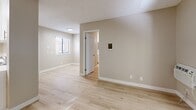 Located at 5925 El Cajon Boulevard in San Diego, CA, this three-bedroom, one-bathroom unit offers a practical and well-appointed single-floor layout. Throughout the space, light wood laminate flooring creates a clean, cohesive look that ties each room together seamlessly.

The living room serves as the central hub of the unit, featuring a wall-mounted HVAC unit, a textured ceiling, and a sliding glass door flanked by vertical blinds that opens directly onto a private balcony — providing natural light and outdoor views of surrounding greenery.

The three bedrooms are finished consistently with the same light wood flooring and neutral warm-beige walls. Each room includes windows fitted with blinds, allowing for adjustable natural light. The spacious primary bedroom also features direct balcony access through its own sliding glass door, while the additional bedrooms offer comfortable, functional spaces with individual wall heater units. Textured ceilings are present throughout.

The bathroom is clean and straightforward, featuring a full tub-shower combination with white surround and chrome fixtures. A pass-through opening between the living area and an adjacent room adds an open, connected feel to the layout. The unit's understated, neutral palette and updated finishes make it a move-in ready space in a well-connected San Diego neighborhood.