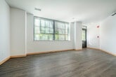 Located at 310 N Franklin St in downtown Madison, WI, this one-bedroom, one-bathroom unit offers a well-designed layout across a single floor. The combined kitchen and living area forms the heart of the unit, featuring light wood-look luxury vinyl flooring, crisp white walls, and warm honey-toned wood baseboards throughout. Large windows fitted with blinds allow natural light to fill the open living space, creating a bright and airy atmosphere.

The kitchen is equipped with warm wood cabinetry, dark charcoal countertops, a double stainless steel sink with a pull-down faucet, and a dishwasher — all accented by track lighting overhead. A convenient pass-through counter separates the kitchen from the living area.

The spacious primary bedroom features plush carpeting, a large multi-pane window for natural light, and two generously sized closets with warm wood panel doors, providing ample storage. An additional closet space is accessible off the hallway.

The bathroom offers tile flooring, a warm wood vanity with a dark countertop and integrated sink, and a tiled shower-tub area. A hallway connects all rooms, completing this clean, functional, and move-in-ready urban residence.