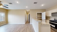 This well-appointed 2-bedroom, 2-bathroom single-story home in El Paso, TX offers a thoughtfully designed layout with modern finishes throughout. Wood-look tile flooring flows consistently across all rooms, lending a cohesive and low-maintenance aesthetic to the entire space.

The open-concept kitchen is a standout feature, equipped with white shaker cabinetry, granite countertops, stainless steel appliances including a gas range, microwave, and refrigerator, and a peninsula with a modern faucet that opens to the living area. A dedicated walk-in pantry provides ample storage. Recessed lighting illuminates the kitchen and living room, enhancing the bright, airy feel.

The living room is generously sized, warmed by neutral beige tones and fitted with a ceiling fan for year-round comfort. A hallway connects the living areas to the private quarters.

The spacious primary bedroom includes a ceiling fan, a window for natural light, and ample room. The second bedroom is a comfortable size with its own ceiling fan and window. Both bathrooms feature granite-topped vanities and wood-look tile flooring, with at least one bathroom offering a tiled walk-in shower with a pebble-stone floor, built-in bench, and decorative tile accents — a refined touch that elevates the overall design of the home.