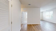 Located at 3225 W Colonial Dr in Orlando, FL, this single-floor, 4-bedroom, 2-bathroom residence offers a clean, modern interior with consistent finishes throughout. The open kitchen-living area is a highlight of the home, featuring crisp white shaker cabinetry, granite-look countertops, stainless steel appliances including a refrigerator, range, microwave, and dishwasher, and warm wood-style plank flooring that extends through the main living spaces. A large window invites natural light into the kitchen, creating a bright and functional area. The living room is open and well-proportioned, with wood-style flooring and neutral walls that provide a versatile backdrop. The four bedrooms are thoughtfully distributed throughout the unit. Several bedrooms feature plush carpeting, ceiling fans, and windows with blinds that let in natural light. The primary bedroom offers a comfortable footprint suited for a full furniture arrangement. Three closets provide ample storage across the unit. The two bathrooms are finished with wood-look tile flooring, granite-topped vanities, and tiled tub-shower combinations with chrome fixtures, lending a clean, contemporary feel. Throughout the home, a neutral color palette, recessed lighting, and consistent flooring choices tie each space together cohesively.