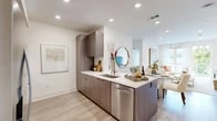 Located at 27942 Forbes Rd in Laguna Niguel, CA, this thoughtfully designed 2-bedroom, 3-bathroom residence offers a modern aesthetic throughout its single-floor layout. The open-concept kitchen and living area serves as the heart of the home, showcasing flat-panel wood-toned cabinetry, crisp white quartz countertops, a peninsula with bar seating, stainless steel appliances, and light wood-look flooring that flows seamlessly throughout. Recessed lighting illuminates the space, enhancing the clean, contemporary feel. The living room is bright and inviting, with large sliding glass doors that open to an outdoor view of lush greenery, filling the space with natural light. The primary bedroom is a comfortable retreat featuring a ceiling fan, floor-to-ceiling windows, and ample natural light. Its ensuite bathroom impresses with large-format marble-look tile flooring, a floating wood vanity with white countertop, and a spacious walk-in closet with custom shelving and hanging systems. Additional bathrooms maintain the same refined design language. A second bedroom and two well-sized closets complete the layout. The overall ambiance is clean, bright, and contemporary, reflecting the elevated Southern California lifestyle.