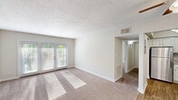 Located at 2041 Shady Grove Way in Louisville, KY, this single-floor, one-bedroom, one-bathroom residence offers a thoughtfully organized layout across a comfortable footprint. The living room is a standout space, featuring elegant French doors that flood the room with natural light and offer views of the outdoors. Plush carpeting, neutral walls, and a textured ceiling create a warm, inviting ambiance throughout.

The dining area flows naturally from the living space, while the kitchen impresses with white shaker cabinetry, granite-look countertops, stainless steel appliances including a refrigerator and range, and durable hardwood-style flooring — a clean, modern contrast to the carpeted living areas. The entrance area also features hardwood-style flooring and includes a ceiling fan for added comfort.

The spacious primary bedroom is carpeted and benefits from natural light via a window, and offers notable storage with two closets featuring classic paneled doors. A hallway connects the main living areas efficiently, with three closets total providing ample storage throughout the home.

The bathroom is well-finished, featuring a full tub-shower combination with elegant marble-style wall surrounds and chrome fixtures. Clean, bright, and move-in ready, this residence combines practical functionality with tasteful finishes.