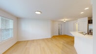Located at 32972 Redstone Drive in New Baltimore, Michigan, this single-floor, 2-bedroom, 2-bathroom home offers a clean, modern aesthetic throughout its thoughtfully arranged layout. The open-concept kitchen and living area serves as the heart of the home, featuring light hardwood flooring, crisp white walls, and stylish ceiling fixtures. The kitchen is well-equipped with rich dark cabinetry, stainless steel appliances including a refrigerator with ice maker, a gas range, and a built-in microwave, all complemented by a white peninsula countertop that provides additional prep and dining space. Recessed lighting adds a polished finish to the kitchen area. The living room extends naturally from the kitchen, bathed in natural light from multiple windows fitted with horizontal blinds. Both bedrooms are carpeted and offer a quiet, comfortable retreat, with the primary bedroom featuring a dedicated closet. The second bedroom benefits from a large window with outdoor views. Both bathrooms are finished with neutral tile, and one features a sleek sliding glass shower enclosure over a tub. A dedicated laundry area includes a full-size washer and dryer with overhead wire shelving. Two closets and a hallway complete this efficiently designed, move-in-ready home.