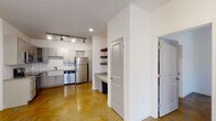 Located at 321 S Swing Rd in Greensboro, NC, this single-story space presents a modern, industrial-inspired aesthetic defined by richly stained and polished concrete floors that flow consistently throughout. The open layout creates a cohesive, versatile environment well-suited to a variety of uses.

The kitchen is a standout feature, outfitted with gray shaker-style cabinetry, granite countertops, a classic farmhouse sink, and a full suite of stainless steel appliances including a refrigerator, range, microwave, and dishwasher. White subway tile backsplash adds a clean, contemporary contrast, while track lighting overhead ensures excellent task illumination. Open wooden shelving and a dedicated built-in desk area with additional cabinetry provide practical workspace and storage solutions nearby.

The main living area is bright and open, featuring a set of double glass entry doors with transom windows that invite natural light. Track lighting supplements the natural illumination throughout.

A private room with a ceiling fan and large windows offers flexible use as a bedroom or office. The bathroom includes a walk-in shower with built-in niches and a granite-topped vanity. An adjacent walk-in closet fitted with wire shelving systems provides generous storage capacity throughout the space.