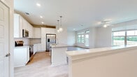 Located in Fairhope, Alabama, this well-designed single-floor residence offers a thoughtfully arranged open-concept layout that maximizes comfort and functionality. The combined kitchen and living area serves as the heart of the home, where crisp white cabinetry, a subway tile backsplash, and granite countertops create a clean, modern aesthetic. A central kitchen island with a built-in sink provides additional workspace and doubles as a casual dining or gathering spot, illuminated by a pair of elegant pendant lights overhead. Stainless steel appliances, including a French door refrigerator, microwave, and range, complete the kitchen. Light hardwood-style flooring runs throughout the space, lending warmth and visual continuity. The living area is generously windowed, with large panes offering sweeping views of open fields and access to an outdoor balcony, filling the space with natural light. A ceiling fan adds to the comfort of the living area. The bedroom is a calm retreat with a ceiling fan, a window overlooking the scenic surroundings, and access to a spacious walk-in closet fitted with wire shelving. The full bathroom features a white vanity with granite countertop, a tub-shower combination, and built-in shelving. The overall ambiance is fresh, bright, and move-in ready.