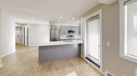Located in the Sage Hill community of Calgary, this well-designed 2-bedroom, 2-bathroom unit offers a clean, modern aesthetic throughout its single-floor layout. Light wood-style flooring flows consistently across the main living areas, complemented by neutral warm-grey walls and crisp white trim that create a bright, cohesive feel.

The open-concept kitchen and dining area serves as the heart of the unit, anchored by a peninsula with a white countertop and undermount sink. Grey cabinetry pairs with a white subway tile backsplash, while stainless steel appliances — including a refrigerator, stove, microwave, and dishwasher — complete the modern kitchen setup. Recessed lighting and windows allow natural light to fill the space.

Both bedrooms are comfortably sized, featuring the same light flooring, neutral walls, and windows that bring in natural light. The primary bedroom includes access to a closet, and the unit benefits from a total of three closets for ample storage. The two bathrooms are finished with large-format tile flooring, grey vanities with white countertops, and black hardware accents — one featuring a soaker tub and shower combination.

A dedicated in-unit laundry room houses a full-sized washer and dryer side by side, adding everyday convenience to this thoughtfully appointed home.