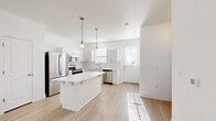 Located in Colorado Springs, CO, this two-story home offers four bedrooms, four bathrooms, and a well-organized layout spread across two floors. The main floor features an open-concept living and kitchen area bathed in natural light, with light-toned luxury vinyl plank flooring throughout. The kitchen is a standout, showcasing white cabinetry with brushed nickel hardware, marble-look quartz countertops, a classic white subway tile backsplash, a central island with seating, pendant lighting, and a full suite of stainless steel appliances. The living area flows seamlessly from the kitchen, creating an ideal space for entertaining. An attached garage with an automatic opener provides convenient parking and additional storage. The upper floor hosts the majority of the bedrooms, each equipped with ceiling fans and ample natural light from well-placed windows. Bedrooms feature plush carpeting and generous closet space, including walk-in closets with wire shelving systems. The bathrooms are finished with marble-look countertops, white cabinetry, and tub-shower combinations. A dedicated utility room and hallway complete the practical, thoughtfully designed floor plan of this clean, modern Colorado Springs home.