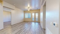 Located at 808 W Orange Grove Rd in Tucson, Arizona, this single-story, 3-bedroom, 2-bathroom home offers a well-organized layout with consistent wood-look tile flooring throughout. The open living area is bright and airy, featuring a ceiling fan, a large window, and French doors with glass panels that invite natural light and provide outdoor access. The kitchen is appointed with white shaker-style cabinetry, dark granite countertops, a peninsula with pendant lighting ideal for casual dining, and stainless steel appliances. It flows seamlessly into the living space, creating an open and connected feel. The spacious primary bedroom includes a dedicated closet outfitted with dual hanging rods and shelving for ample storage. The two bathrooms feature matching white vanities with granite countertops, large mirrors, and tile flooring. A central hallway connects the bedrooms efficiently, with high ceilings adding to the sense of openness. The neutral warm-toned walls throughout complement the light flooring, creating a cohesive and clean aesthetic. Each bedroom benefits from natural light via windows, and the overall layout makes practical use of every square foot of this well-appointed Tucson home.