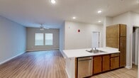 Located at 3825 Jonesboro Rd in South Fulton, GA, this single-story, 3-bedroom, 1-bathroom residence offers a practical and modern layout designed for comfortable everyday living. The open-concept kitchen and living area serves as the heart of the home, where a peninsula with a double stainless steel sink and white countertops flows seamlessly into the living room. The kitchen is equipped with warm wood-toned cabinetry, a stainless steel refrigerator, and a range with overhead ventilation. Wood-style flooring runs throughout the main living areas, complemented by recessed lighting and a ceiling fan that enhance the bright, airy atmosphere. A dedicated laundry area with an in-unit washer and dryer adds everyday convenience. The primary bedroom is a well-proportioned retreat featuring dual windows, a ceiling fan with light kit, and wood-style flooring. The additional bedrooms offer carpeted floors, ceiling fans, natural light from windows with blinds, and closets with wire shelving for organized storage. The bathroom is thoughtfully designed with accessibility features, including grab bars, a roll-in shower area, and wood-style flooring. Neutral wall tones and clean finishes throughout give the space a fresh, move-in-ready appeal.
