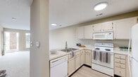 Located at 3401 BremerHall Ct in Raleigh, NC, this one-bedroom, one-bathroom residence offers a well-organized, single-floor layout with a clean and neutral aesthetic throughout. The open-concept kitchen and living area form the heart of the home, with the kitchen showcasing white cabinetry, light countertops, a double-basin stainless steel sink, a full suite of white appliances including a dishwasher, electric range, over-the-range microwave, and refrigerator, as well as light wood-look flooring. Recessed lighting illuminates the kitchen, which flows seamlessly into the carpeted living area, where a large window invites natural light and views of the surrounding greenery. The spacious bedroom features plush carpeting, a ceiling fan, a window with outdoor views, and direct access to a private balcony through a glass-panel door — offering a pleasant outdoor retreat. A dedicated closet provides convenient storage. The bathroom maintains the home's consistent neutral palette with light flooring and clean finishes. Textured ceilings are present throughout, adding subtle architectural character. The overall ambiance is bright, functional, and move-in ready, making this Raleigh residence a practical and comfortable living space.