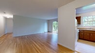Located at Scott Court in Ridgefield Park, NJ, this single-floor residence offers a clean, functional layout with consistent hardwood flooring throughout. The main living area is generously proportioned, featuring light-toned hardwood floors, neutral gray-toned walls, and a sliding glass door that opens to a private balcony overlooking lush greenery — allowing natural light to fill the space. The living area flows into a well-defined kitchen equipped with warm wood cabinetry, a double-basin sink, granite-style countertops, and a built-in dishwasher, along with a window framing outdoor views. The bedrooms are comfortably sized and share the same hardwood flooring, each outfitted with wall-unit air conditioning, baseboard heating, and large multi-pane windows that bring in abundant natural light and wooded views. Closet storage is present throughout, including a double-door closet visible in one of the bedroom areas. The entry foyer provides a welcoming transition into the home with an additional closet for storage. Baseboard heating is consistent across all rooms. The overall ambiance is bright, neutral, and move-in ready, with a practical design suited for comfortable everyday living in a quiet residential setting.
