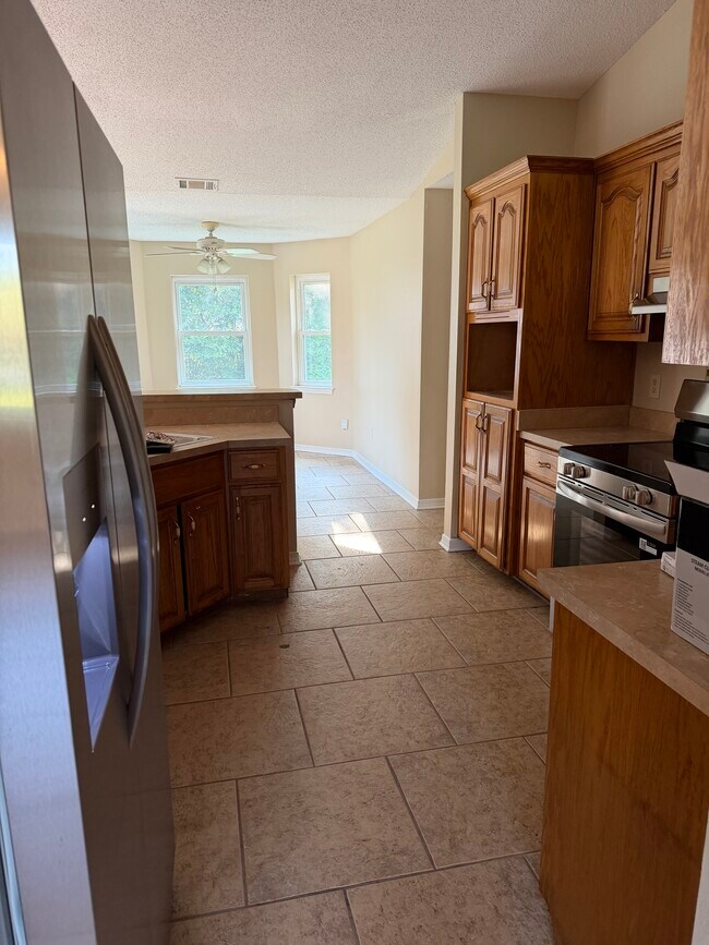 Cocina con barra de desayuno y vista abierta a la sala de estar. - 6281 Hunters Ridge Dr