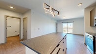 Located in Cleveland's vibrant Ohio City neighborhood, this well-designed one-bedroom, one-bathroom unit offers a modern open-concept layout with light wood-style flooring throughout. The kitchen is a standout feature, showcasing sleek flat-front cabinetry in a warm taupe finish, stone-look countertops, a subway tile backsplash, and a full suite of stainless steel appliances including a refrigerator with ice maker, electric range, microwave, and dishwasher. A generous kitchen island with an eye-catching geometric pendant light serves as a natural divider between the kitchen and the bright, airy living room. The living room opens directly to a private balcony through a sliding glass door, offering impressive views of the Cleveland skyline. The bedroom is a calm, sunlit retreat with large windows that also frame the city skyline, complemented by a spacious walk-in closet with wire shelving for ample storage. A second closet provides additional flexibility. The bathroom features clean white tile, a soaking tub with terrazzo-accented surround, and matte black hardware and fixtures throughout. In-unit laundry adds everyday convenience, rounding out this thoughtfully appointed urban residence.
