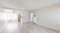 Located at 12323 Texas Ave in the desirable West Los Angeles neighborhood of 90025, this 2-bedroom, 2-bathroom single-floor unit offers a clean, modern aesthetic with thoughtfully updated finishes throughout. Light wood-style flooring runs continuously across all rooms, creating a cohesive and bright interior feel.

The living room is a well-proportioned open space bathed in natural light through large windows dressed with vertical blinds, offering views of neighborhood greenery including palm trees. A wall-unit heater provides convenient climate control.

Both bedrooms are comfortably sized, with the primary bedroom offering ample floor space. Each room features a ceiling fan with light fixture, large windows with vertical blinds for natural light and privacy, and neutral gray walls that complement the flooring.

The kitchen is outfitted with white shaker-style cabinetry, matte black hardware, light quartz countertops, and stainless steel appliances including a range and dishwasher, delivering a crisp, contemporary look.

The main bathroom features a white vanity with an undermount sink, matte black fixtures, a soaking tub with overhead shower, and a window above for natural light. The second bathroom includes a compact white vanity and a glass-enclosed shower. Both bathrooms maintain a clean, all-white palette with wood-look flooring.