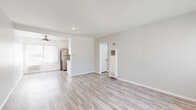 Located at 12323 Texas Ave in the desirable West Los Angeles neighborhood of 90025, this 2-bedroom, 2-bathroom single-floor unit offers a clean, modern aesthetic with thoughtfully updated finishes throughout. Light wood-style flooring runs continuously across all rooms, creating a cohesive and bright interior feel.

The living room is a well-proportioned open space bathed in natural light through large windows dressed with vertical blinds, offering views of neighborhood greenery including palm trees. A wall-unit heater provides convenient climate control.

Both bedrooms are comfortably sized, with the primary bedroom offering ample floor space. Each room features a ceiling fan with light fixture, large windows with vertical blinds for natural light and privacy, and neutral gray walls that complement the flooring.

The kitchen is outfitted with white shaker-style cabinetry, matte black hardware, light quartz countertops, and stainless steel appliances including a range and dishwasher, delivering a crisp, contemporary look.

The main bathroom features a white vanity with an undermount sink, matte black fixtures, a soaking tub with overhead shower, and a window above for natural light. The second bathroom includes a compact white vanity and a glass-enclosed shower. Both bathrooms maintain a clean, all-white palette with wood-look flooring.