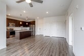 This single-floor residence at 4424 Washington St in Kansas City, MO offers a clean, contemporary design with a thoughtful layout and quality finishes throughout. The open-concept living and dining area is anchored by warm wood-tone flooring, recessed lighting, and a ceiling fan, creating a bright and functional gathering space. Large windows invite natural light and offer views of the surrounding neighborhood's greenery.

The kitchen is a standout feature, equipped with rich dark espresso cabinetry, a white geometric tile backsplash, quartz countertops, stainless steel appliances, and a generously sized center island with pendant lighting above — ideal for both meal preparation and casual dining.

The bedrooms are carpeted for comfort and each includes a ceiling fan. The primary bedroom connects to an en-suite bathroom featuring a dual-sink vanity with quartz countertops, dark cabinetry, and wood-style flooring. A walk-in closet provides ample storage. A secondary bathroom offers a tiled tub-shower combination, single vanity, and matching dark cabinetry. The overall aesthetic is modern and neutral, offering a versatile backdrop throughout.
