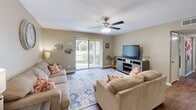 Located at 31 Trillium Cir in Dothan, Alabama, this 2-bedroom, 2-bathroom single-floor residence offers a well-organized and comfortable layout. The living room serves as the heart of the home, featuring wood-look flooring, a ceiling fan, and a sliding glass door with vertical blinds that fills the space with natural light and provides views of the surrounding greenery outside. The adjoining dining area is a defined space with warm neutral walls and a textured ceiling, ideal for everyday meals. The galley-style kitchen is efficiently designed with rich dark cabinetry, light countertops, wood-look flooring, and black appliances including a range and refrigerator, offering ample storage and prep space. The primary bedroom is generously sized with plush carpeting, a window with natural light, and access to a closet. The second bedroom is similarly comfortable and carpeted. Both bathrooms are clean and functional, featuring neutral tones and wood-look flooring. A dedicated in-unit laundry room accommodates a full-size washer and dryer with overhead shelving for added convenience. Throughout, the home maintains a cohesive warm neutral palette with textured ceilings, creating a welcoming and practical living environment.
