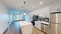 Located at 4591 McRee Ave in St. Louis, MO, this well-designed one-bedroom, one-bathroom unit offers a thoughtful open-concept floor plan that maximizes its efficient footprint. Light-toned hardwood-style flooring flows consistently throughout, tying each room together cohesively.

The kitchen is a standout feature, outfitted with white shaker cabinetry, a green subway tile backsplash, stainless steel appliances — including a range, microwave, and dishwasher — and a generous central island with a crisp white countertop. Dual pendant lights hang above the island, complemented by recessed lighting overhead. The kitchen opens seamlessly into the living area, which is equipped with a ceiling fan and benefits from natural light filtering in through a window.

The bedroom is comfortably sized, featuring large windows that invite abundant natural light and offer outdoor views. A ceiling fan adds practical comfort, and the room connects to a dedicated closet for storage.

The bathroom is clean and modern, presenting a white vanity with a quartz-style countertop, black hardware accents, hardwood-style flooring, and a glass-door walk-in shower. The consistent use of white walls, black hardware, and warm flooring throughout gives the entire space a fresh, contemporary aesthetic.