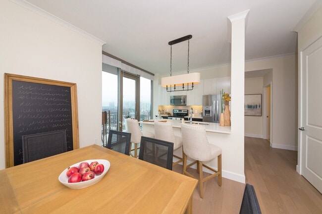 Los ventanales que van del suelo al techo permiten la entrada de abundante luz natural y enmarcan las vistas del horizonte desde este luminoso comedor. - The Residence Buckhead Atlanta