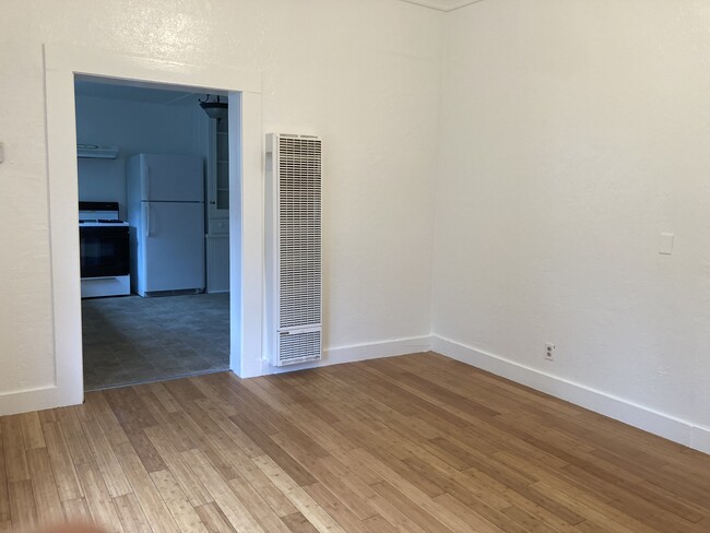 living room looking to kitchen. Wall heater. - 219 S Pine St