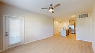 Located at 1105 Grassy Lake Dr in Davenport, Florida, this well-appointed 3-bedroom, 2-bathroom single-floor residence offers a thoughtfully designed layout with modern finishes throughout. Light wood-style flooring flows seamlessly across every room, creating a bright and cohesive aesthetic.

The open-concept kitchen and living area serves as the heart of the home, anchored by a central island with a built-in sink and crisp white countertops. The kitchen is equipped with stainless steel appliances, including a side-by-side refrigerator, and features taupe cabinetry with clean, contemporary lines. Recessed lighting illuminates the space, which opens directly into the living room — outfitted with a modern ceiling fan and large windows that invite abundant natural light and views of the lush Florida surroundings.

Each of the three bedrooms is comfortably sized, featuring ceiling fans, neutral walls, and ample natural light. The primary bedroom connects to a well-designed bathroom showcasing a marble-tiled soaking tub, a sleek dual-sink vanity with warm wood cabinetry, and a large mirror with vanity lighting. Generous closet space is provided throughout, including a walk-in closet with wire shelving systems. Additional bedrooms offer double-door closets and outdoor views framed by palm trees, reinforcing the home's bright, airy Florida character.