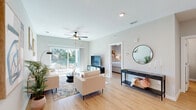 Located at 5180 NE 71st Ave in Wildwood, FL, this well-appointed 1-bedroom, 1-bathroom single-story home offers a thoughtfully designed layout with modern finishes throughout. Light wood-tone luxury vinyl plank flooring flows seamlessly across the entire space, creating a cohesive and airy feel.

The open-concept living, dining, and kitchen area forms the heart of the home. The bright living room features a ceiling fan, large sliding glass doors that flood the space with natural light, and direct access to a private outdoor patio. The kitchen is outfitted with gray shaker-style cabinetry, white quartz countertops, stainless steel appliances, a central island with pendant lighting and seating, and an adjacent pantry for added storage.

The bedroom is a comfortable retreat with a ceiling fan, a window with natural light, and direct access to a dedicated closet. The full bathroom features a gray double-vanity with white countertops, pendant lighting, wood-look flooring, and a tub-shower combination. A separate laundry area accommodates a full-size washer and dryer with overhead shelving. A utility room provides additional functional space, completing this efficiently organized and stylishly finished home.