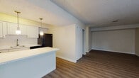 Located at 765 E 400 S in Salt Lake City, Utah, this single-floor unit offers a practical and well-designed layout suited for comfortable everyday living. The open-concept design seamlessly connects the kitchen and living area, creating a cohesive and functional space throughout.

The kitchen is outfitted with crisp white cabinetry, light countertops, and a full suite of black appliances including a refrigerator, dishwasher, and range. A peninsula counter extends into the living space, providing additional prep area and a natural dividing point between the kitchen and the rest of the unit. A stylish pendant light hangs above, adding a subtle decorative touch.

The living area is generously proportioned, featuring durable wood-look flooring that extends throughout the unit. Neutral, light-toned walls complement the space, while a sliding glass door with vertical blinds allows natural light to filter in and provides access to the outdoors. Textured ceilings are present throughout.

A closet with sliding doors is conveniently situated between the kitchen and the living area, offering practical storage. The bathroom features white cabinetry with a light countertop, a large mirror, a louvered closet door, and a separate water closet, combining functionality with a clean, bright aesthetic.