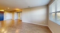 Located at 888 N San Mateo Dr in San Mateo, CA, this well-appointed 2-bedroom, 2-bathroom residence offers a thoughtfully designed single-floor layout with a generous overall footprint. The open-concept living area features warm hardwood-style flooring, recessed lighting, and large windows that invite abundant natural light and views of the surrounding greenery. The kitchen is outfitted with rich dark-wood cabinetry, white countertops, and a full suite of stainless steel appliances including a refrigerator, electric range, and built-in microwave, making it both functional and visually striking. Both bedrooms are carpeted for comfort, with the spacious primary bedroom offering a walk-in closet with built-in shelving and wire rack storage. The second bedroom also benefits from natural light through a large window with views of nearby trees. Each of the two bathrooms is finished with a tub-shower combination featuring sliding glass doors, a dark-wood vanity, and clean white fixtures. Additional conveniences include a dedicated laundry area, a utility room, multiple hallways for ease of circulation, and a private balcony. The neutral color palette and consistent finishes throughout create a cohesive, modern ambiance.