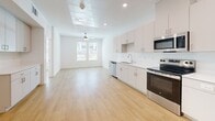 Located at 4850 W Rome Blvd in Las Vegas, Nevada, this one-bedroom, one-bathroom unit offers a clean, modern design throughout. Light-toned wood flooring flows seamlessly across the entire space, creating a warm and cohesive aesthetic. The open-concept living and kitchen area is bright and airy, illuminated by recessed lighting, a skylight panel feature, and a ceiling fan that enhances air circulation. The kitchen is well-equipped with a full suite of stainless steel appliances, including a refrigerator, electric range, built-in microwave, and dishwasher. Crisp white cabinetry extends floor-to-ceiling, providing generous storage, while white countertops and a clean tile backsplash complete the contemporary look. The living area flows naturally toward a window that invites natural light and outdoor views. The bedroom is a comfortable, well-proportioned retreat featuring a ceiling fan and a large window overlooking greenery outside. The bathroom is finished with white cabinetry, dual mirrors, and white countertops, maintaining the unit's consistent modern style. A hallway connects the bedroom and bathroom efficiently. The overall ambiance is clean, minimalist, and move-in ready, reflecting a thoughtfully designed modern living space in northwest Las Vegas.