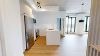 Located at 9450 Rue Meilleur in Montréal, this modern 3-bedroom, 3-bathroom unit offers a well-designed layout across a single floor. The open-concept kitchen and living area serves as the heart of the space, featuring a contemporary kitchen with white cabinetry, stainless steel appliances, a built-in microwave, and a large white quartz island with an undermount sink — ideal for both cooking and casual dining. Light hardwood flooring flows throughout, complementing the clean, minimalist aesthetic.

A defining architectural feature is the exposed concrete ceiling, which adds an industrial character that contrasts beautifully with the bright white walls. The bedrooms are well-proportioned, with the primary suite offering access to a closet and a private ensuite bathroom. Black-framed floor-to-ceiling windows and balcony doors flood the rooms with natural light while framing open city views. The bathrooms are finished with large-format tiles, glass-enclosed showers, and sleek white vanities.

A dedicated laundry closet with stacked washer and dryer units adds everyday convenience. The overall ambiance is clean, modern, and urban — a thoughtfully designed space suited for contemporary living in the heart of Montréal.