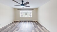Located at 415-419 S Main St in North Syracuse, NY, this 2-bedroom, 1-bathroom unit offers a practical and well-appointed single-floor layout. Hardwood-style flooring flows consistently throughout the living areas and bedrooms, complementing the clean, neutral walls that create a bright and cohesive aesthetic.

The living room is a comfortable, open space featuring a ceiling fan with integrated lighting and a large window that draws in natural light and outdoor views. An adjacent dining area offers its own window and an elegant chandelier overhead. Both rooms benefit from baseboard heating for year-round comfort.

The kitchen is efficiently designed in a U-shaped layout, outfitted with white cabinetry, granite-style countertops, a stainless steel sink, and white appliances including an electric range and refrigerator. Tile flooring and a window add practicality and light to the workspace.

The primary bedroom is generously sized, with a ceiling fan, large window, and a sliding closet for ample storage. The second bedroom also features natural light through its windows and baseboard heating. Both rooms maintain the same warm hardwood-style flooring.

The bathroom is clean and functional, featuring tile flooring, a full bathtub with shower, a toilet, and a vanity with granite-style countertop. A hallway connects the rooms, completing this efficient and move-in-ready layout.
