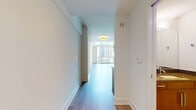 This contemporary two-story space offers a generous 1,140 square feet of living area, split between a 500 sq ft ground floor and a 640 sq ft upper level. The upper floor, showcased in the image, exemplifies modern design with its open concept and minimalist aesthetic. Pristine white walls create a bright, airy atmosphere, complemented by wall-to-wall carpeting in a neutral tone. A standout feature is the sleek metal railing that borders the open area, likely overlooking the floor below. Large windows flood the space with natural light, enhancing the sense of openness. Overhead, a modern ceiling fan with wooden blades provides both function and style. The room's clean lines and uncluttered appearance suggest a flexible space that could serve various purposes, from a living area to a home office. While specific room details are limited, the property's layout hints at a thoughtful design that maximizes space and light across its five rooms.