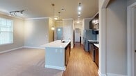 Located at 2013 Copper Leaf Pkwy in Durham, NC, this single-floor home offers a thoughtfully designed layout with attractive finishes throughout. The entryway welcomes you with rich hardwood flooring, crown molding, and a convenient closet near the front door. The open-concept kitchen is a standout feature, showcasing dark espresso cabinetry, stainless steel appliances including a French door refrigerator and range, a tile backsplash, and a large center island with a built-in sink and pendant lighting overhead. Track lighting and crown molding add a polished touch to the space. The living area flows seamlessly from the kitchen, featuring plush carpeting, a ceiling fan, and multiple windows dressed with blinds that invite natural light. The bedrooms are generously sized with soft carpet, neutral wall tones, and natural light from double windows. One bedroom includes built-in shelving, ideal for use as a home office or study. The bathrooms are well-appointed: one features a tiled soaking tub with an arched alcove, dark vanity cabinetry, and wood-look flooring, while another offers a glass-enclosed tiled shower with a sleek vanity. Together, these spaces create a comfortable and functional home.