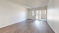 Located at 2104 S Lewis St in Anaheim, California, this 2-bedroom, 2-bathroom unit offers a clean, modern interior spread across a single floor. The open-concept living and dining area is bright and airy, featuring light wood-look flooring, crown molding, and a ceiling fan. A sliding glass door leads to a private balcony, bringing in natural light and outdoor views. The kitchen is well-appointed with white shaker cabinetry, marble-style countertops, a gas range with hood, and a skylight that enhances the sense of openness. Both bedrooms are comfortably sized with large windows fitted with vertical blinds for light control. The primary bedroom features mirrored sliding closet doors, adding depth to the space. The second bedroom similarly benefits from natural light and direct hallway access. Each bathroom is finished with white cabinetry, marble-style countertops, a single vanity with a large mirror, and a tub-shower combination with tiled surround. Wood-look flooring carries throughout the unit, lending a cohesive and contemporary aesthetic. A connecting hallway efficiently links the bedrooms and bathrooms. The overall design is clean and neutral, providing a versatile canvas throughout.